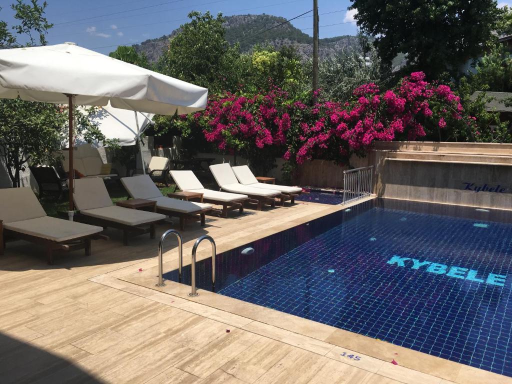Havuz ve otel binası pembe çiçeklerle